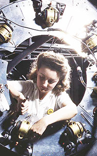 Woman reviewing the cowling of one of the motors of a B-25 bomber